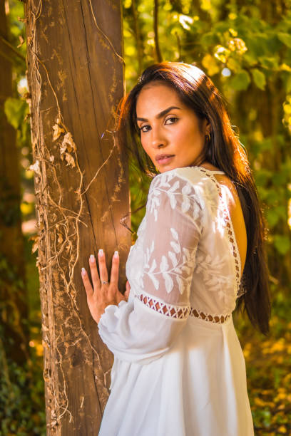 istock Young Latin brunette enjoying a park in a white dress 1438113121