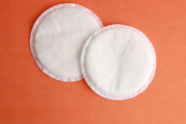 istock Flat lay of white absorbent nursing pads on an orange background 1438113781