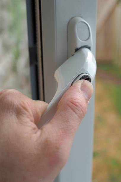 istock Vertical shot of a white window lock with a handle on a PVC window frame 1438117536