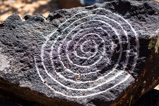 A close up of a rock with a spiral circle petroglyph in the Petroglyph National Monument