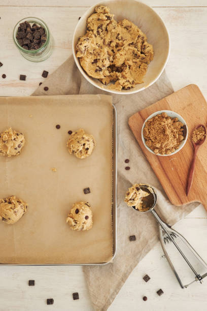 istock Vertical top view of chocolate chips dough balls on an oven tray 1438118675