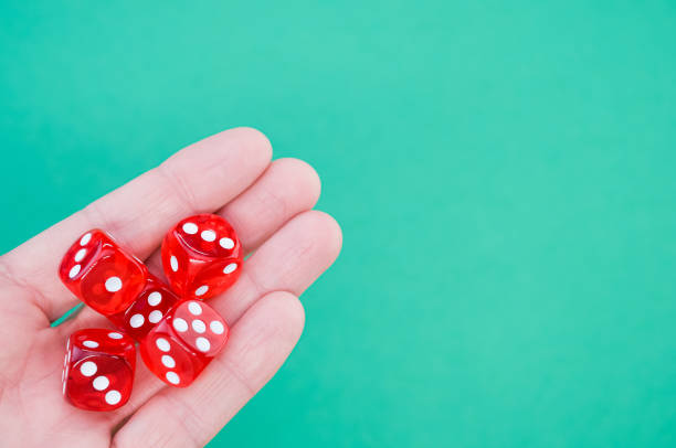istock Closeup of red rolling dice on a blue background 1438119160