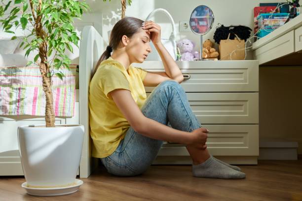 sad teenage girl sitting on the floor at home - teenager teenagers only one teenage girl only human face imagens e fotografias de stock