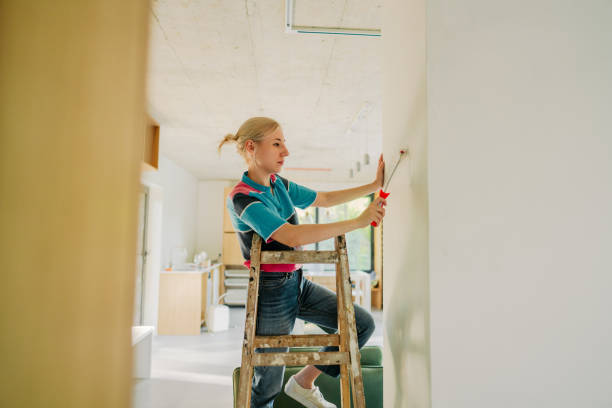 istock Young woman painting a wall 1438121071