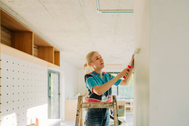 istock Young woman painting a wall 1438121072