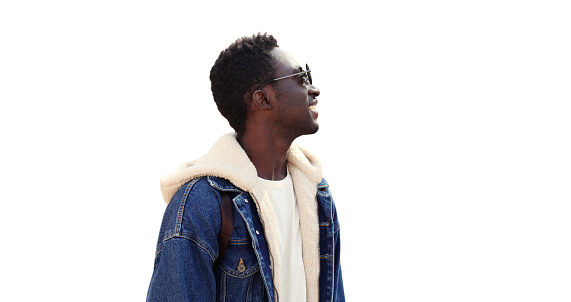 Portrait of smiling young african man looking away wearing sunglasses, jean jacket isolated on white background