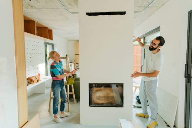 istock Loving couple painting a wall together 1438121152