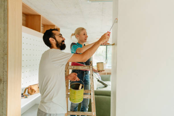 istock Loving couple painting a wall together 1438121200