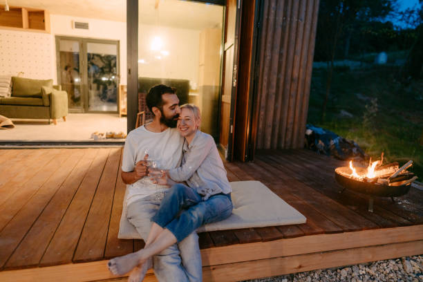 istock Young couple drinking wine by the fire pit 1438123448