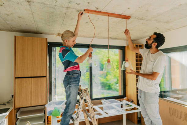 Fixing lighting equipment in our home Photo of a young couple fixing lighting equipment in their new home diy stock pictures, royalty-free photos & images