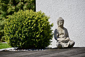 istock Little statue of Buddha outside the house on a sunny day 1438127609