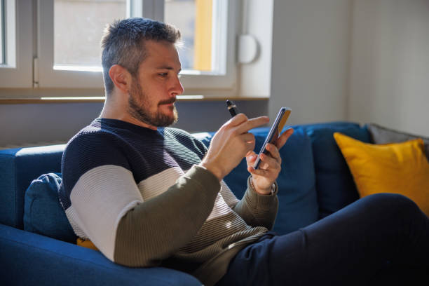 istock Man sitting on the sofa at home and scrolling on smart phone 1438127754