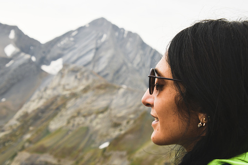 Close up caucasian woman face closed eyes inhale fresh mountains air in nature outdoors.Altitude respiratory adaptation concept.Enjoy life and travel and moment concept