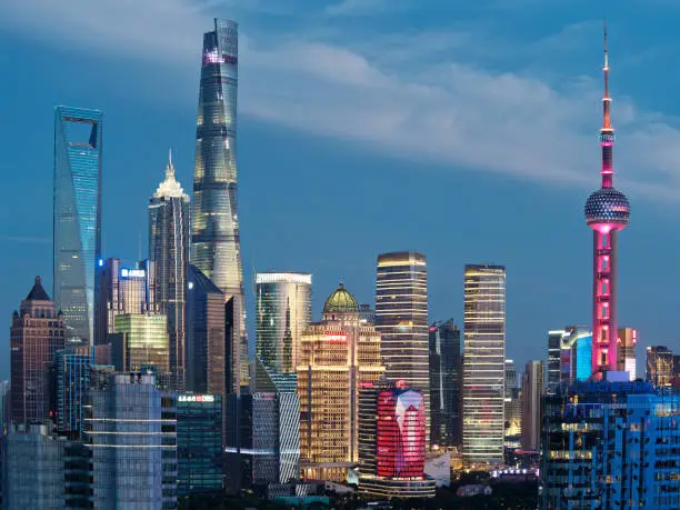 Photo of modern skyscrapers, Shanghai tower, jin mao tower, oriental pearl TV tower and shanghai world financial center, landmarks in lujiazui with blue sky background in dusk