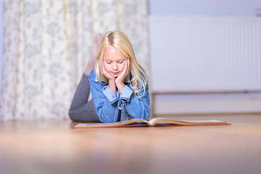 Ten year old comfy reading on the sitting room floor.