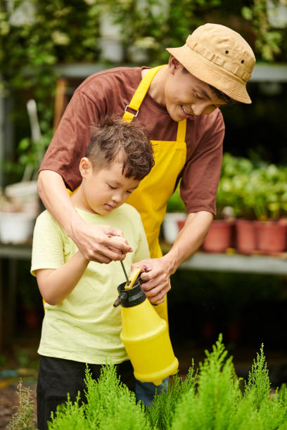 istock Father and Son Watering Plants 1438130344