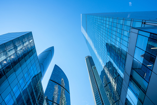 Skyscrapers, business buildings at sunny day with clear blue sky, looking up