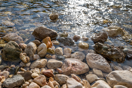 Kieselsteine am Fluss Glan glitzern im Sonnenschein