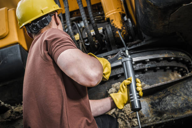 construction worker performing excavator maintenance - lubrication imagens e fotografias de stock