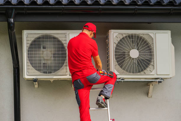Heating and Cooling Technician Performing Scheduled Heat Pump Unit Service stock photo
