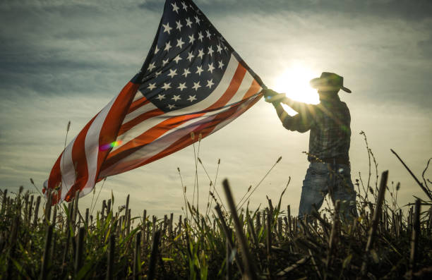 Man Shows Love of Country by Waving American Flag stock photo