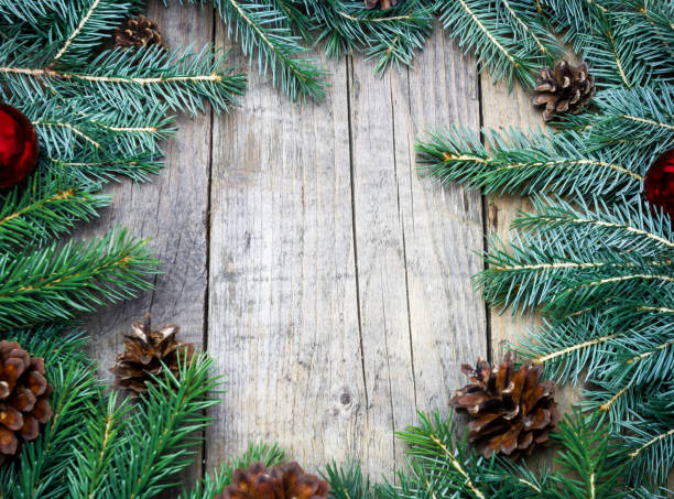 istock Fur-tree branches and cones frame on wooden background 1438137057