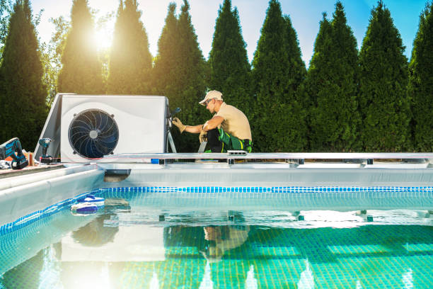 Swimming Pool Heat Pump Installation Performed by Professional HVAC Technician stock photo