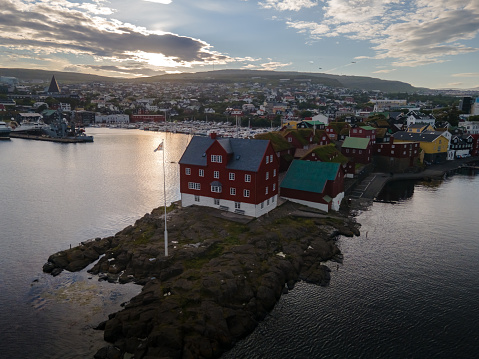 View of the beautiful city of Torshavan in the Faroe Islands Governments colorful red building  with grass on the roof , and marina