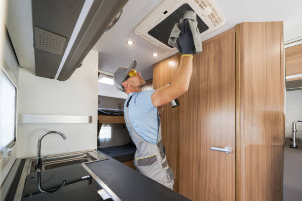 RV Rental Company Worker Cleaning Motorhome Air Condition Unit stock photo