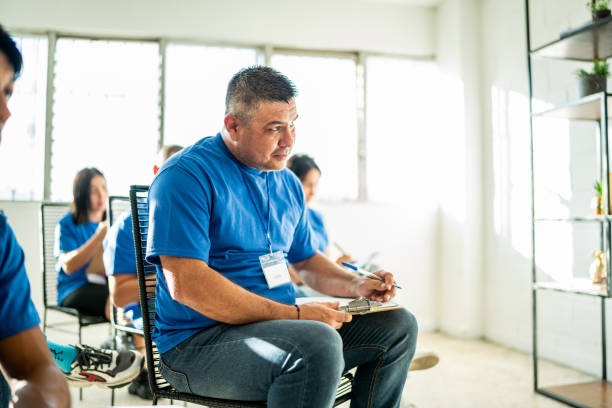 istock Mid adult man taking notes on a clipboard during meeting at community center 1438138071