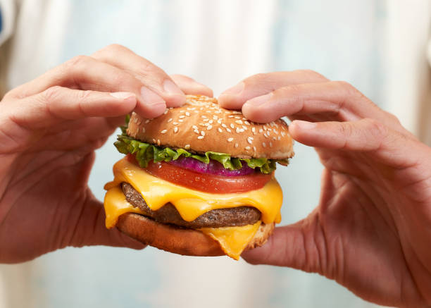istock football fan holding hamburger whit two hands 1438143613