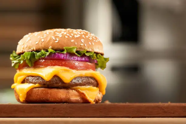 Photo of double cheese beef burger with kitchen background