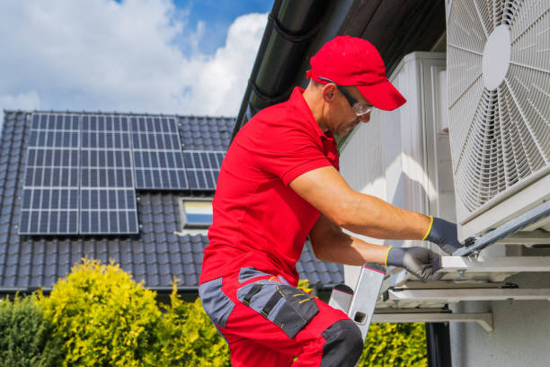 hvac worker performing heat pump maintenance - installeren stockfoto's en -beelden