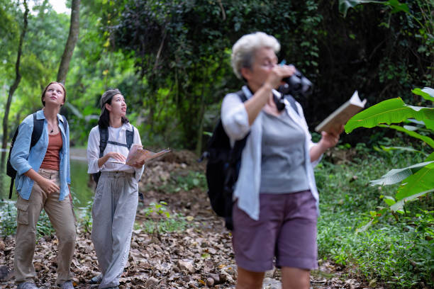 istock Backpack tourist travel outdoor adventure bird study using binoculars looking and record to book 1438145096