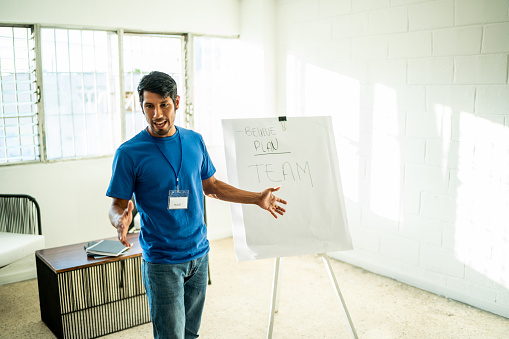 Mid adult volunteer man giving a presentation at community center