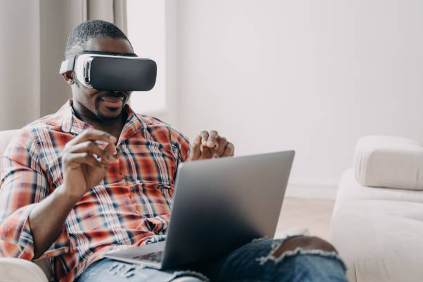 istock African american man software developer wearing virtual reality glasses works, creates app at laptop 1438145534