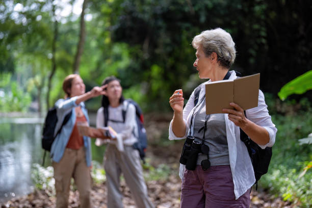 istock Backpack tourist travel outdoor adventure bird study using binoculars looking and record to book 1438145697