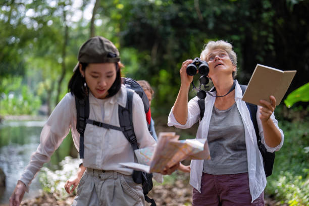 istock Backpack tourist travel outdoor adventure bird study using binoculars looking and record to book 1438145727