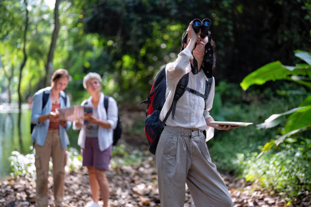 istock Backpack tourist travel outdoor adventure bird study using binoculars looking and record to book 1438146460