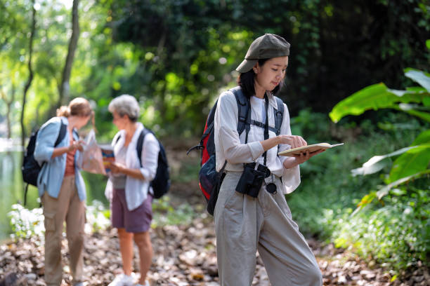 istock Backpack tourist travel outdoor adventure bird study using binoculars looking and record to book 1438146917