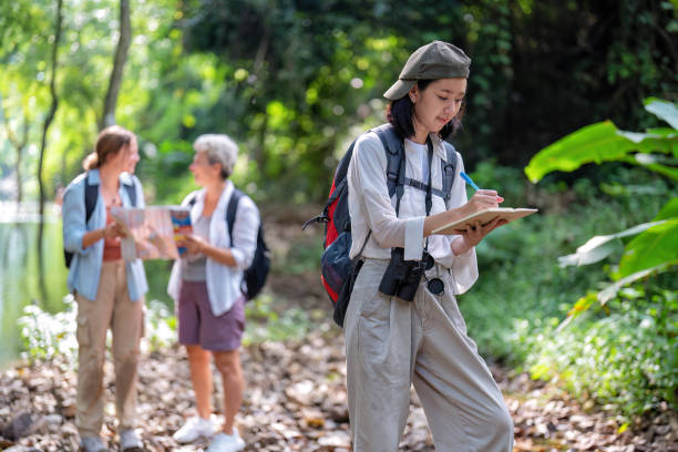 istock Backpack tourist travel outdoor adventure bird study using binoculars looking and record to book 1438146949