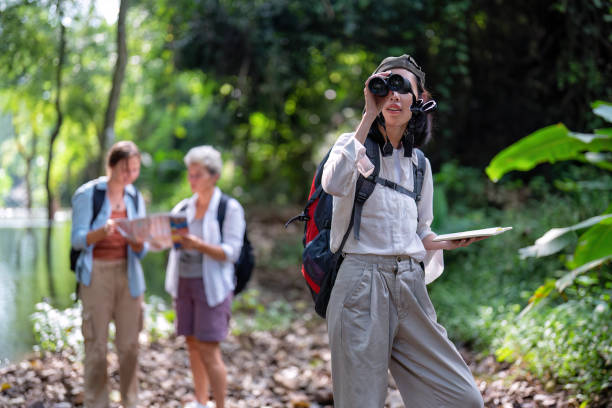 istock Backpack tourist travel outdoor adventure bird study using binoculars looking and record to book 1438147010