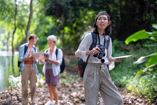 istock Backpack tourist travel outdoor adventure bird study using binoculars looking and record to book 1438147120