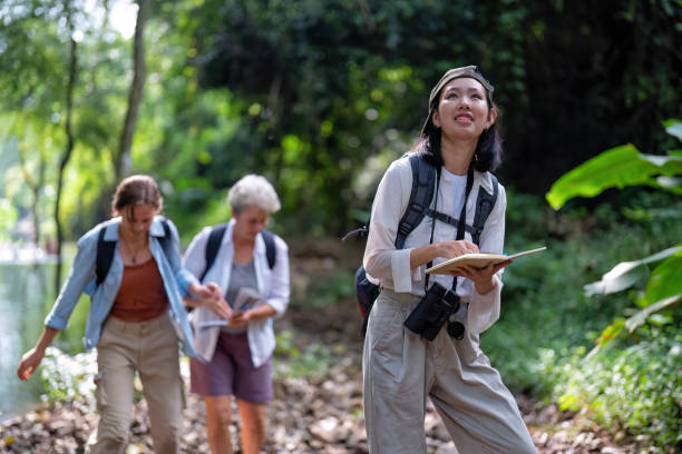 istock Backpack tourist travel outdoor adventure bird study using binoculars looking and record to book 1438147361