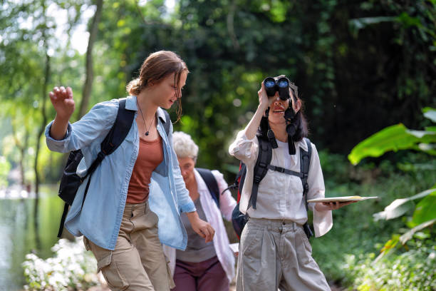istock Backpack tourist travel outdoor adventure bird study using binoculars looking and record to book 1438147392