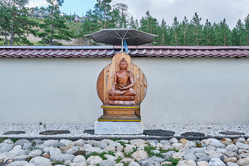Ulan-Ude, Russia - August 17, 2022: Buddha statue in the garden of good thoughts. Japanese rock garden. Buddhist datsan Rinpoche Bagsha on Bald Mountain.