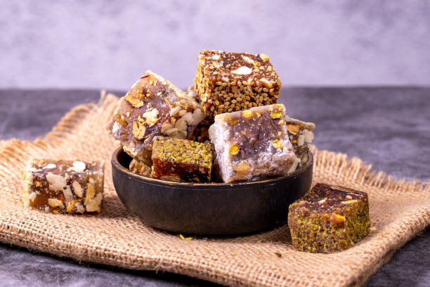 istock Mixed Turkish delight varieties on a dark background. Pistachio, hazelnut and fruit flavored Turkish delights. close up 1438147694