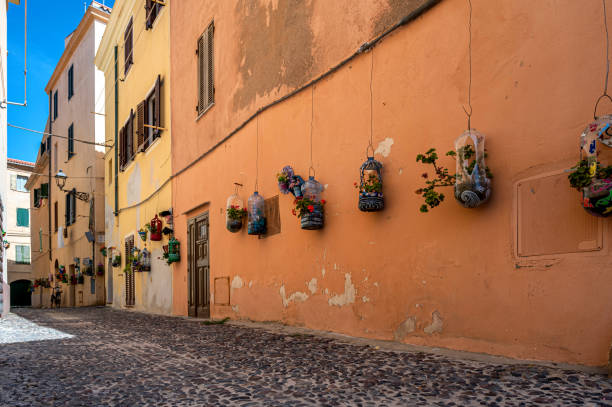 zdobiona fasada w wąskiej uliczce na starym mieście alghero na sardynii - alghero zdjęcia i obrazy z banku zdjęć