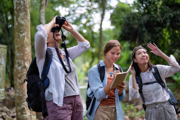istock Backpack tourist travel outdoor adventure bird study using binoculars looking and record to book 1438148233