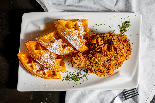 Belgian waffles on slate plate on dark wooden background. Top view. Copy space